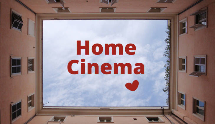 Eine Häuserschlucht von unten Fotografiert, damit der Himmel aussieht wie eine Leinwand. im Himmel steht der Text Home Cinema und ein Herz